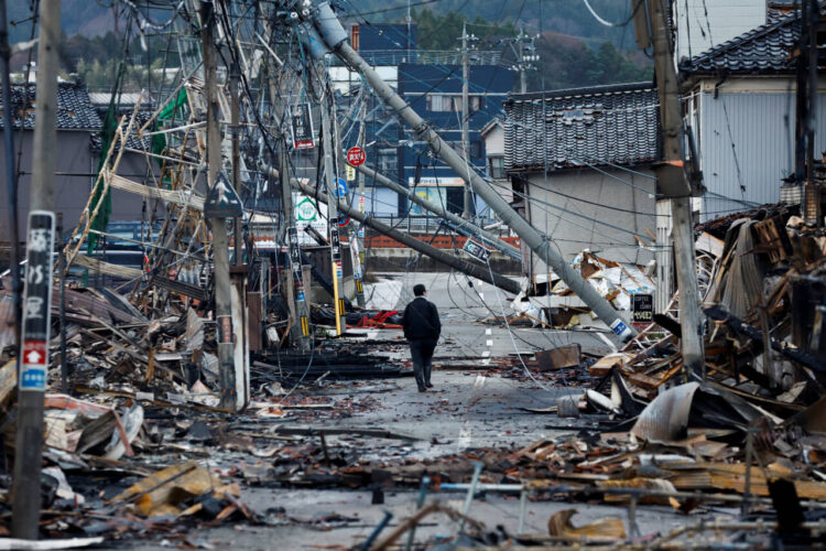 A man makes his way along Asaichi-dori street, which burned down due to a fire following an earthquake, in Wajima, Japan, January 4, 2024. REUTERS/Kim Kyung-Hoon