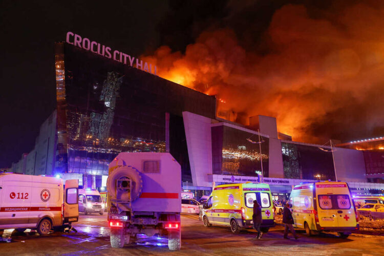 Vehicles of Russian emergency services are parked near the burning Crocus City Hall concert venue following a reported shooting incident, outside Moscow, Russia, March 22, 2024. REUTERS/Maxim Shemetov