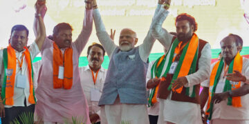 Ballari, Apr 28: Prime Minister Narendra Modi holds hands with Bharatiya Janata Party (BJP) candidate from Ballari rural seat B Sriramulu and others at a public meeting for the third phase of the Lok Sabha elections, in Ballari on Sunday.