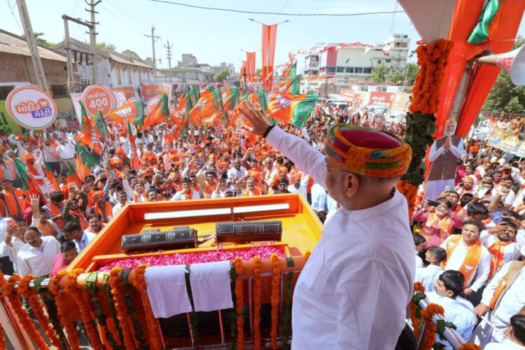 Union Home Minister Amit Shah waves at BJP supporters during a roadshow in Gandhinagar