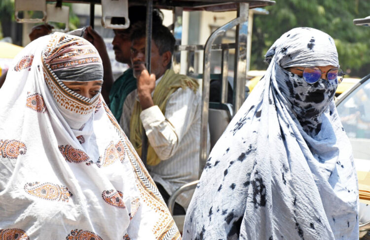 Kanpur, May 28: Women cover their faces with scarves to protect themselves from the scorching sun on a hot summer day, in Kanpur on Tuesday.