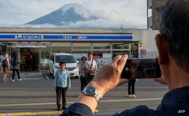 A Japanese town was set to mount a large mesh barrier across the road from an Instagram-famous view of Mount Fuji in an attempt to deter badly behaved tourists.