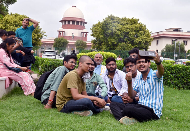 New Delhi, Jul 08 : Students wait outside as the hearing is going on regarding the alleged irregularities in NEET UG 2024 in the Supreme Court, in New Delhi on Monday.