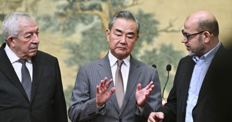 Mahmoud al-Aloul, Vice Chairman of the Central Committee of Palestinian organisation and political party Fatah, China's Foreign Minister Wang Yi, and Mussa Abu Marzuk, senior member of the Palestinian Islamist movement Hamas, attend an event at the Diaoyutai State Guesthouse in Beijing