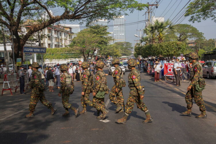 FILE PHOTO: Soldiers cross a street as people gather to protest against the military coup, in Yangon, Myanmar