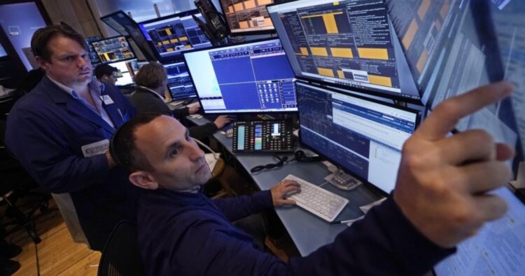 A pair of traders work in their booth on the floor of the New York Stock Exchange, Thursday, Nov. 7, 2024. (AP Photo/Richard Drew)